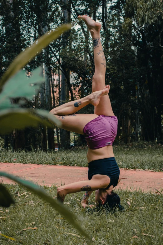 a woman doing a hand stand on her back