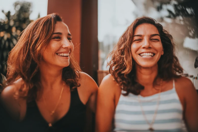 two women smile as they stand next to each other