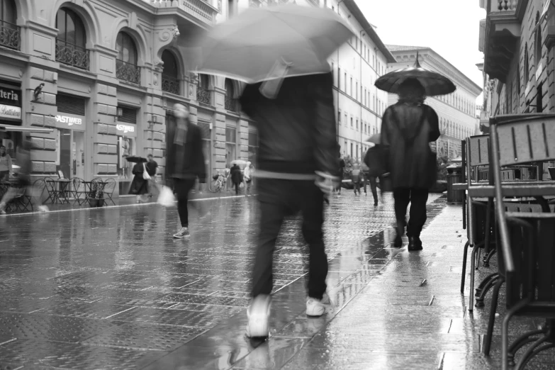 people walking down a city street with umbrellas