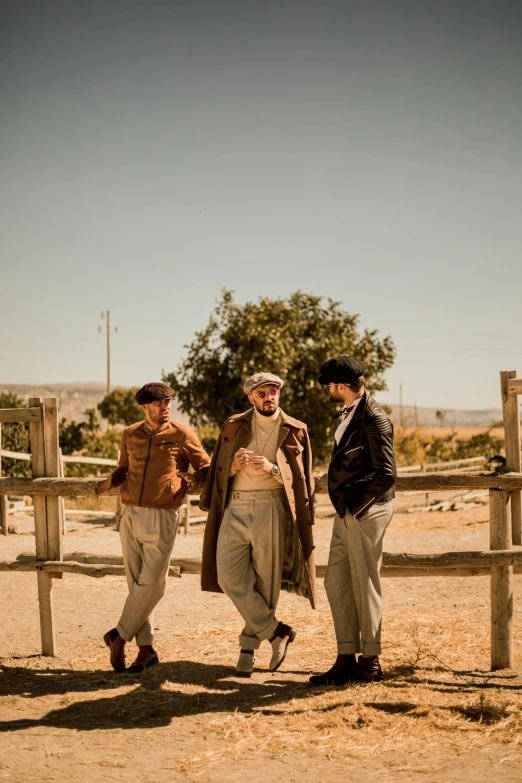 three young men stand in a fenced area