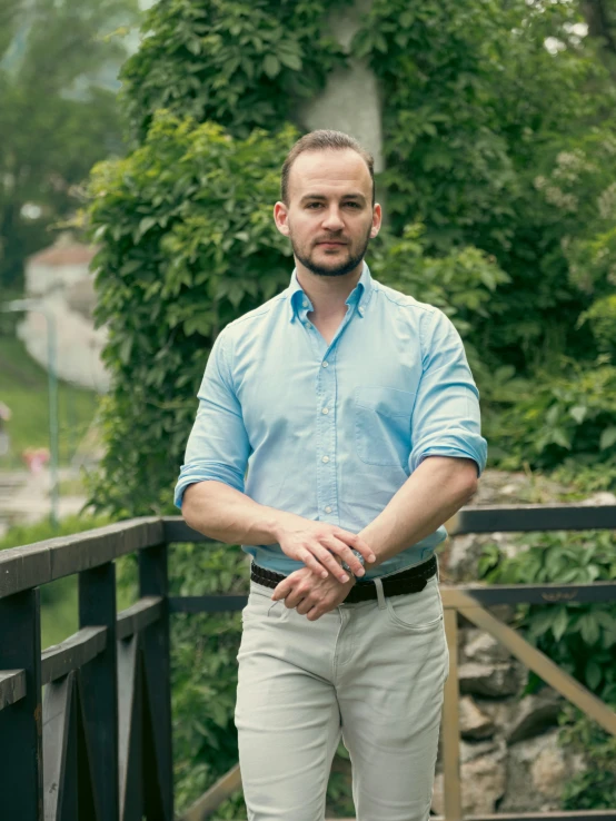 man standing on a bridge with his hands crossed