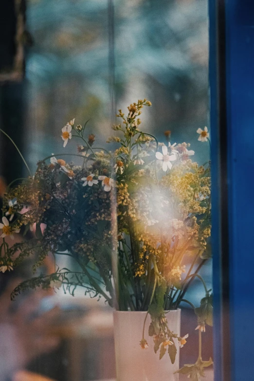 flowers are in a vase near the window