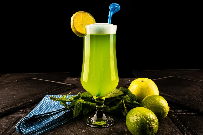 a glass with a drink and some limes on the table