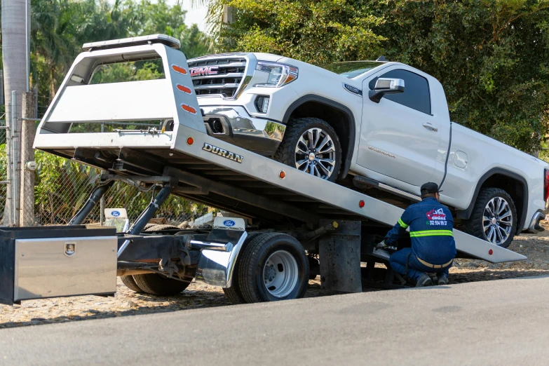 a white truck with its flatbed turned on its tow truck