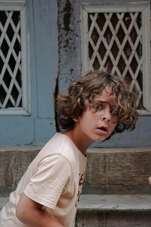 a boy sitting on some steps with a tennis racket