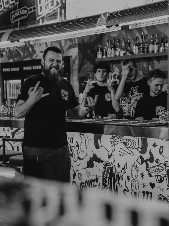 the man in black is standing at the bar with other people