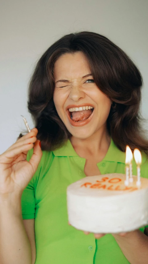 a woman holding a cake that has some candles on it