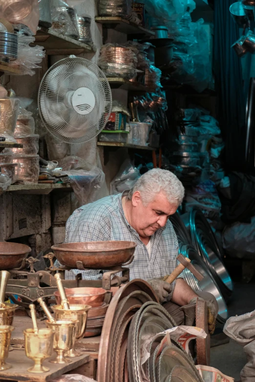 an elderly man standing in a shop next to his antiques