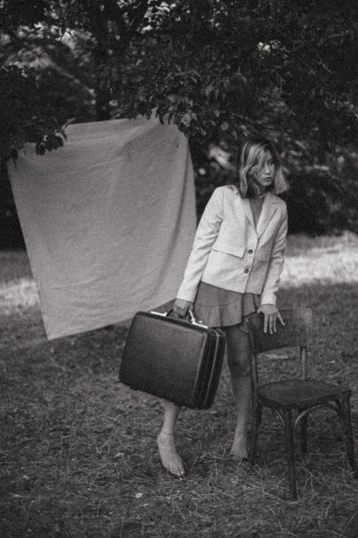 a black and white po of a lady in an advert with her luggage