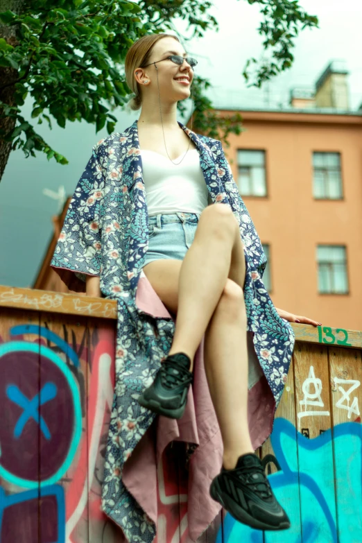 a woman sitting on the side of a fence