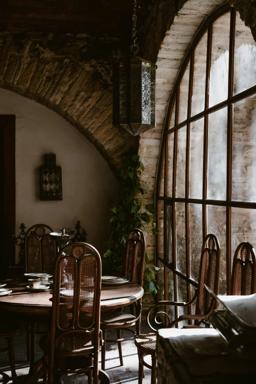 the inside of an old fashioned looking restaurant with wooden chairs and round windows