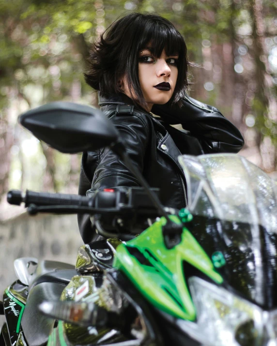 a woman in black outfit sitting on a motorcycle