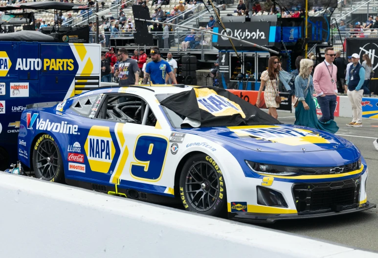 a white and yellow race car in front of people