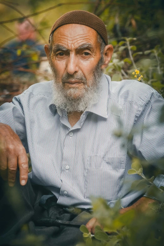 the elderly man poses for a portrait while wearing a hat