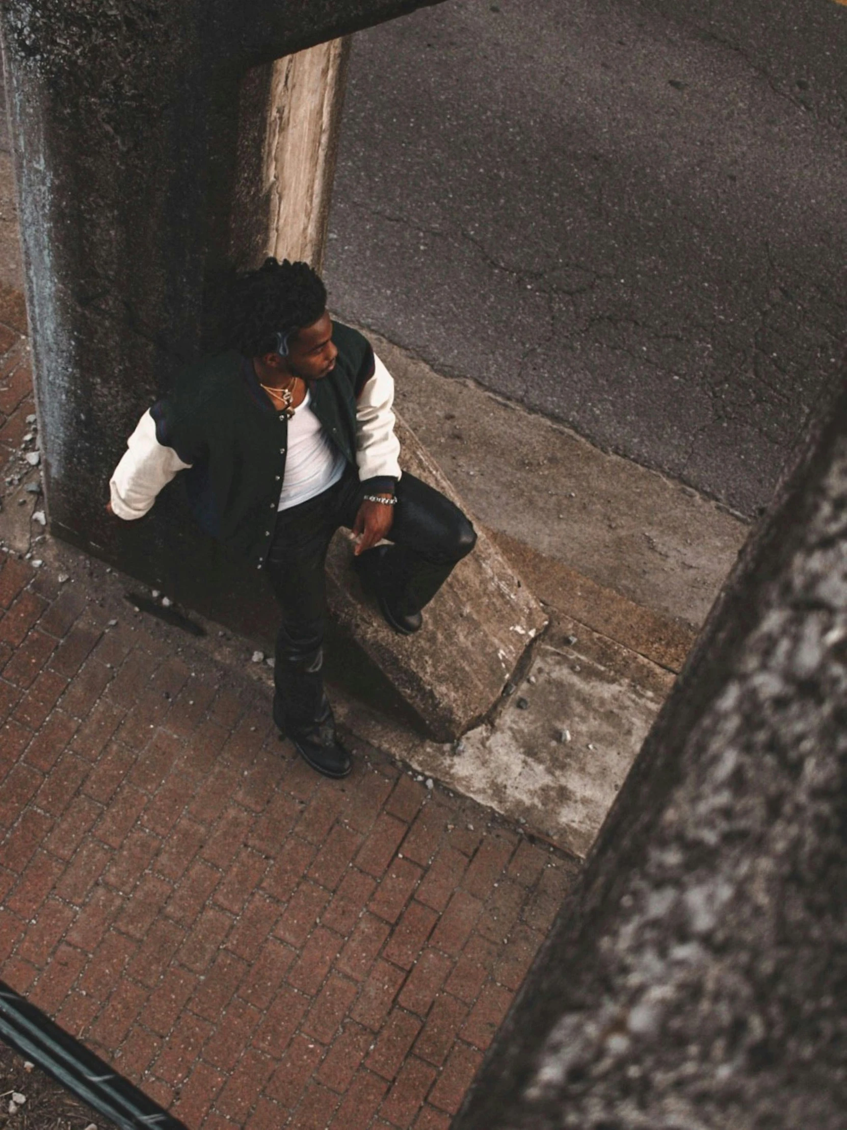 a man sitting on the sidewalk with a phone