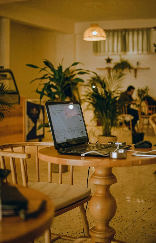 an open laptop computer on top of a wooden table