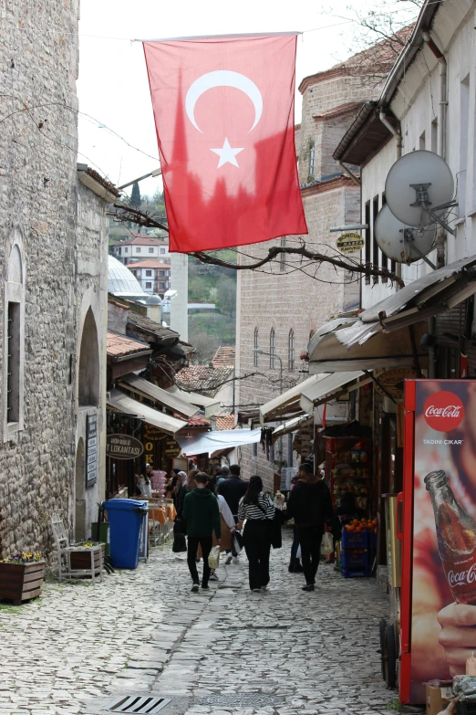 an ottoman - turkish flag over a crowded street in turkey