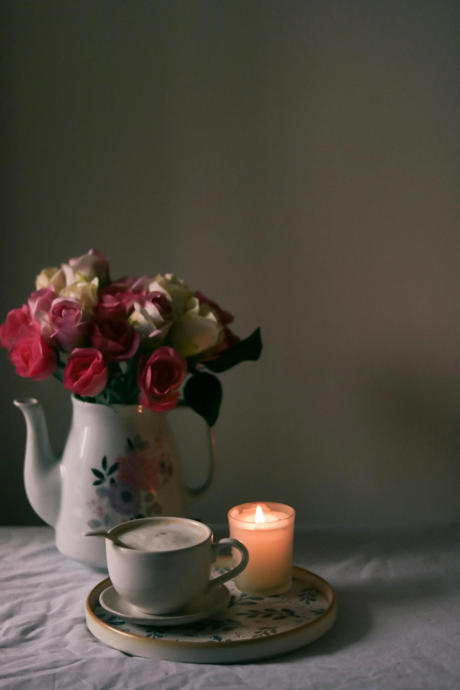 a tea pot with a lit candle next to it