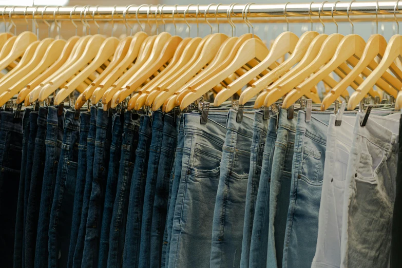 a rack full of clothing hanging on wooden rail