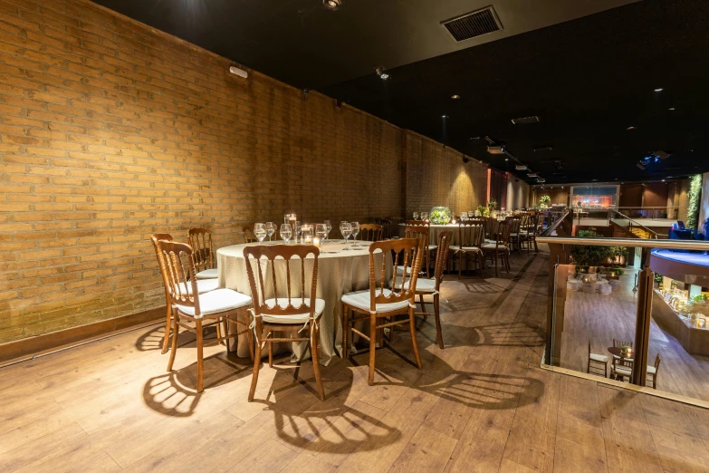 a dining area inside a restaurant with brick wall and large tables