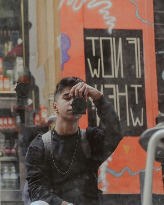 the young man is sitting down with his camera to take a po