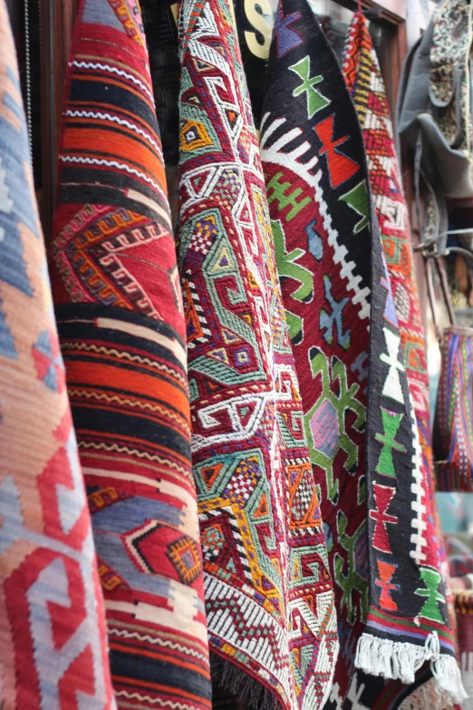 some colorful carpets are hanging on a wall