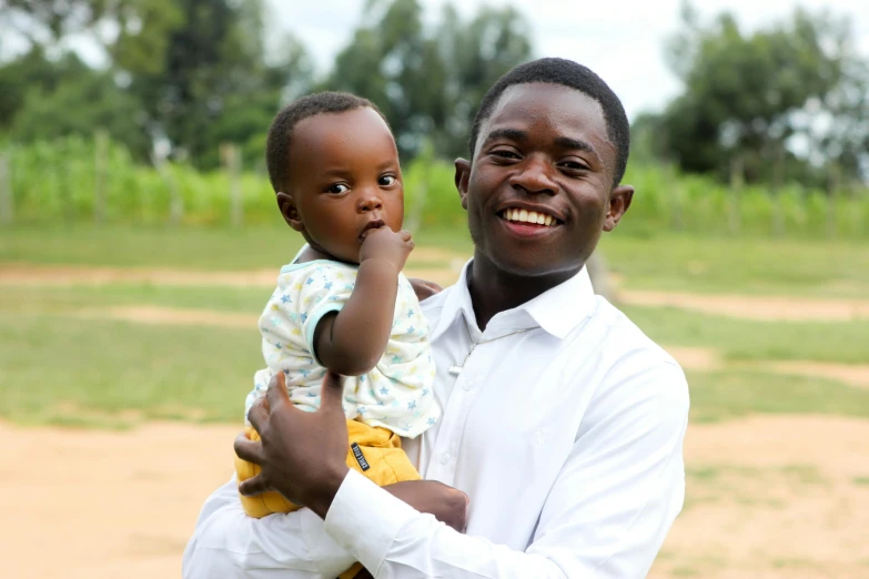 a man holding up a small child in a field
