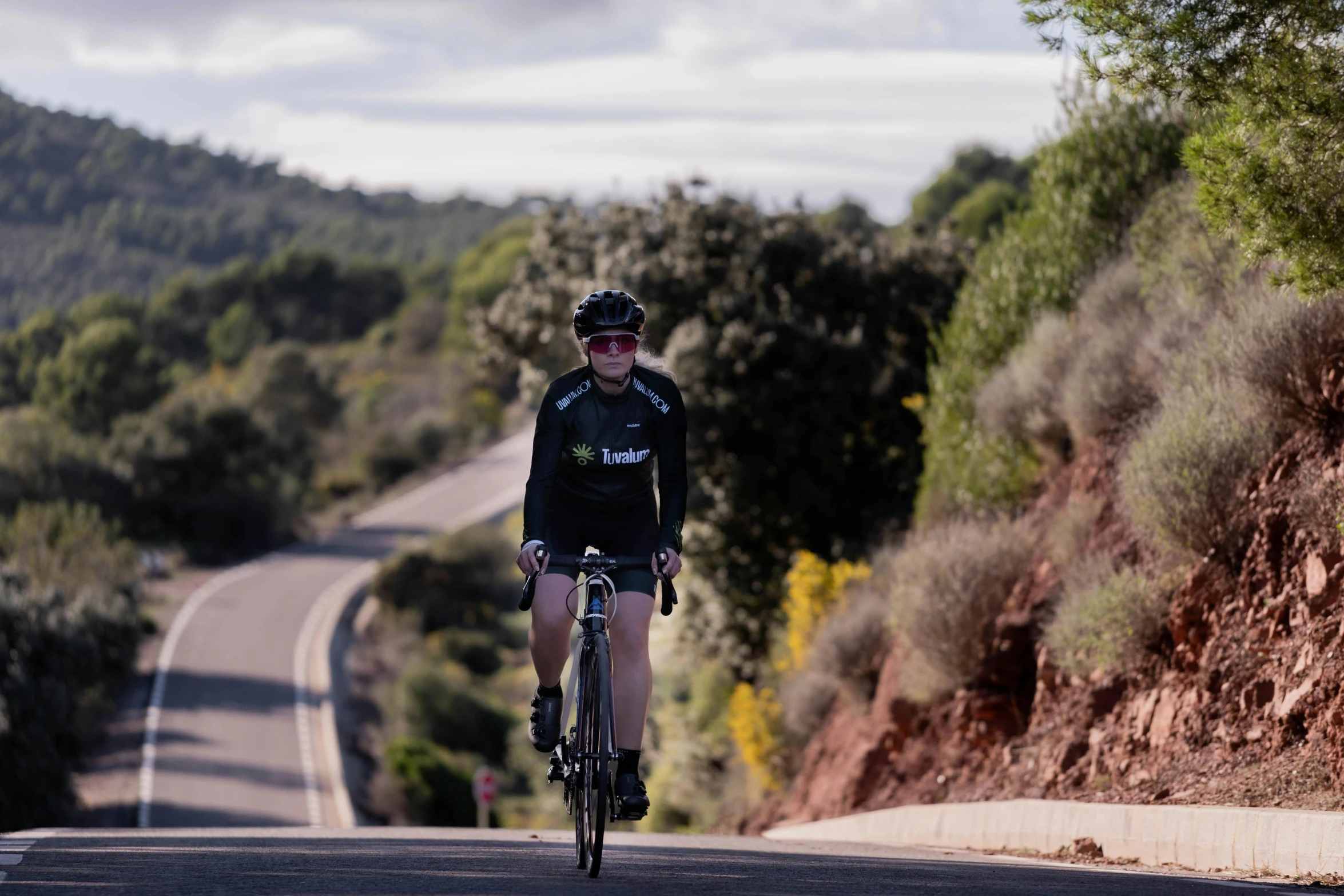 a person riding a bike down a road in the mountains