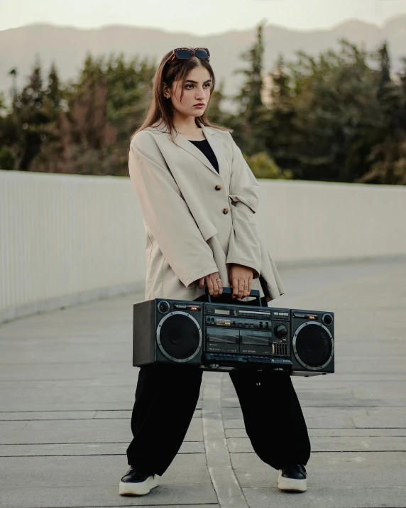 the woman is carrying a radio case while posing