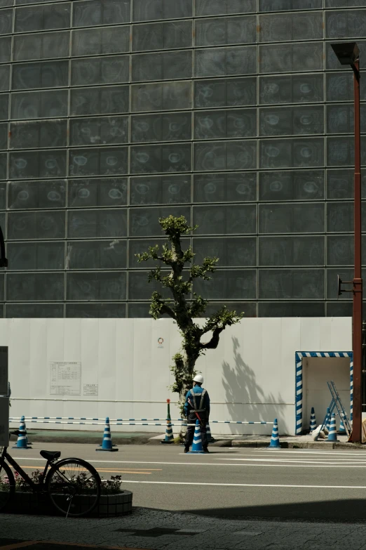 a man is walking down the street as traffic cones are around him