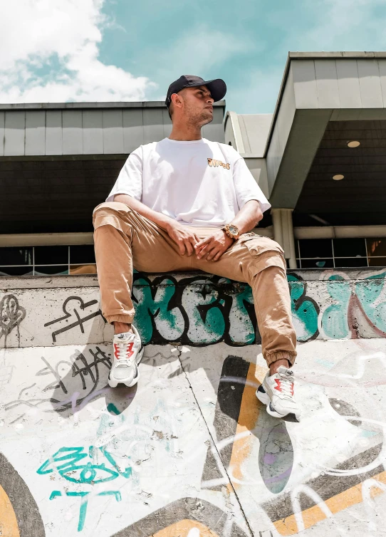 a man sitting on top of a skateboard ramp