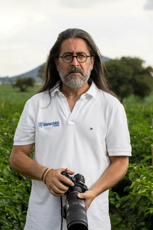 a man holding a camera with a sky in the background