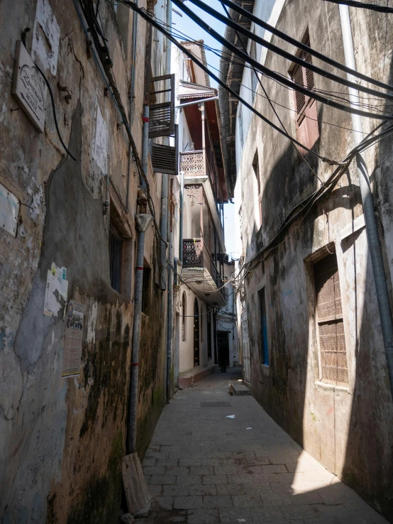 an alley with telephone wires and a bench