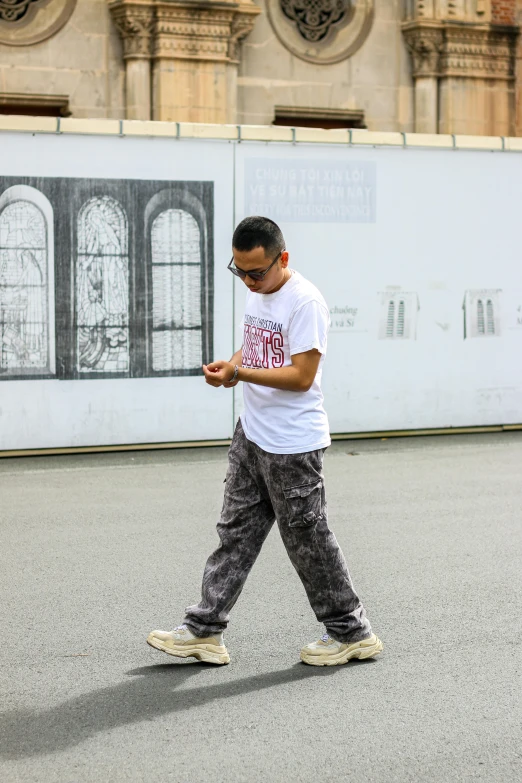 a young man is using his cell phone in the street