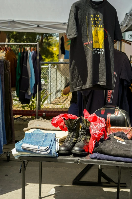 clothing hangs on a table outside at an open air stand