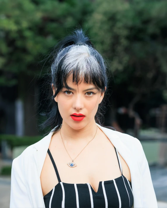 a woman with a cropped black top and red lipstick is wearing a pinstripe outfit