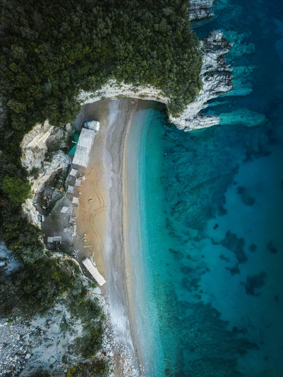 an aerial view of the beach and water in a rocky area