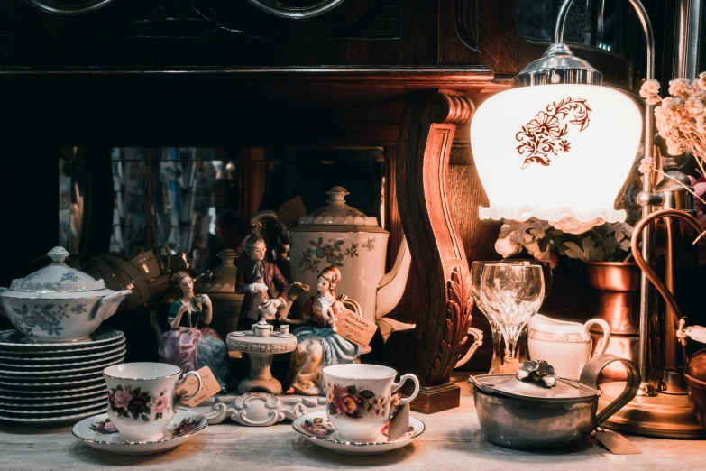 there is a variety of tea cups and plates sitting on a table