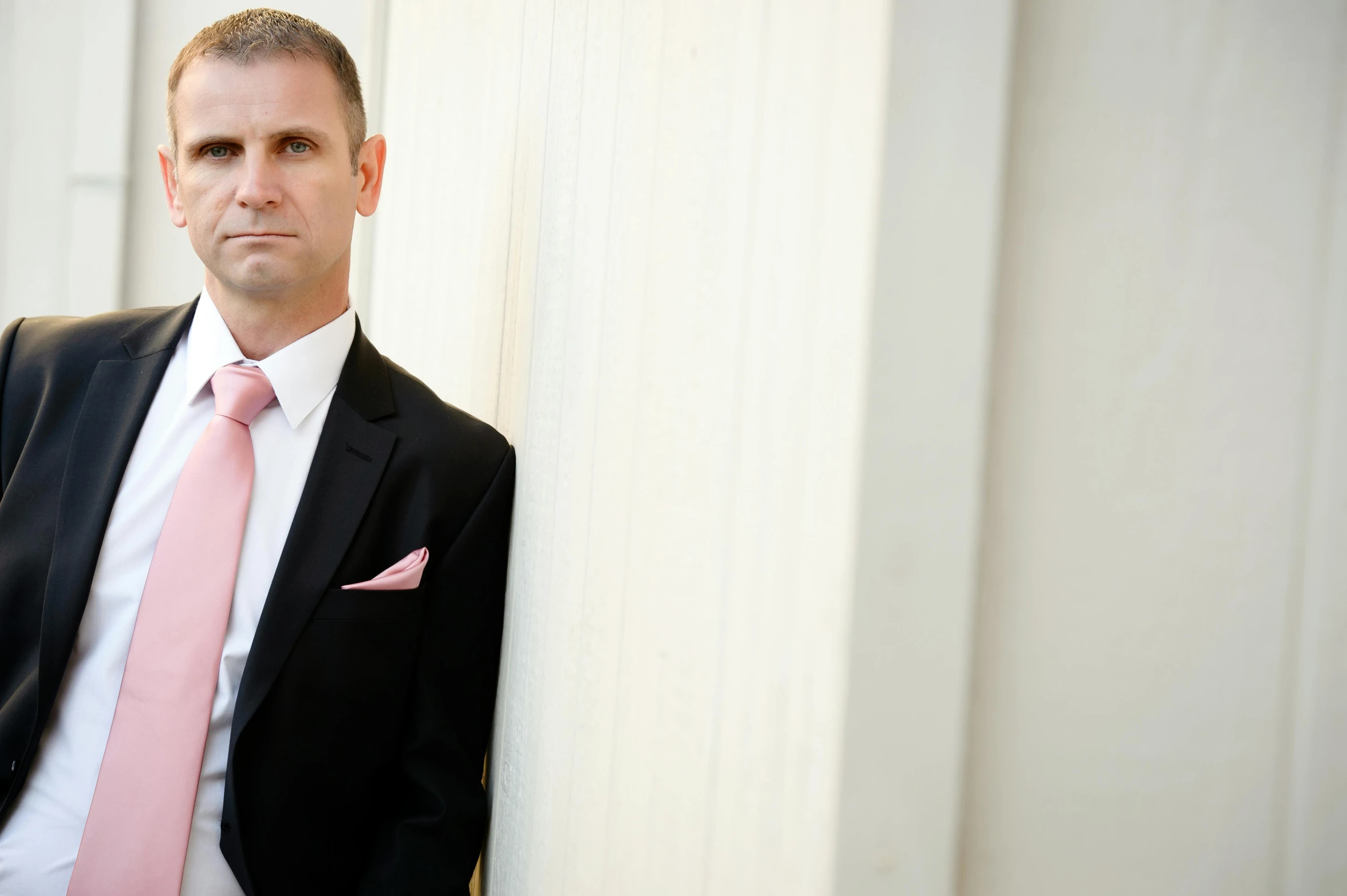 man with pink tie posing for a portrait