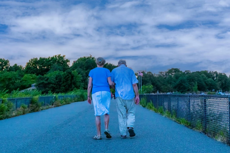 two people walking down the road holding hands