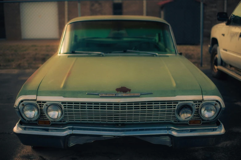 a green car parked on top of a driveway