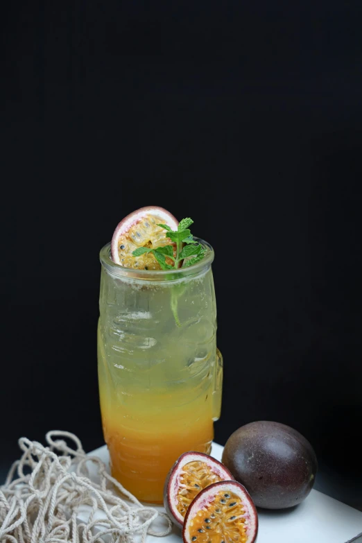 a pitcher with liquid filled with some kind of substance next to sliced gfruits