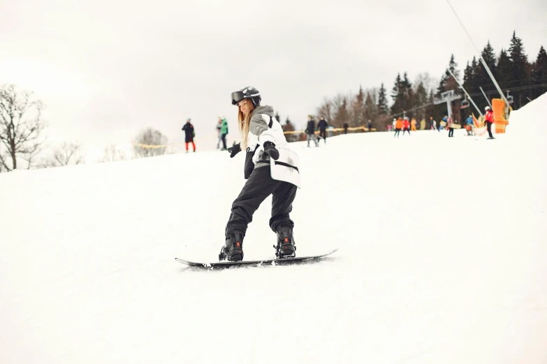 a person is wearing black ski pants and riding on a snowboard