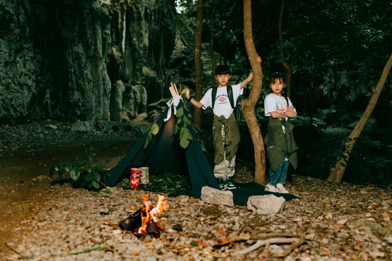 two children sitting at the campsite with their camping gear