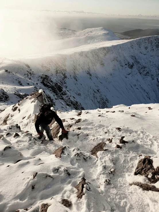 a person kneeling down with their snowboard on a mountain