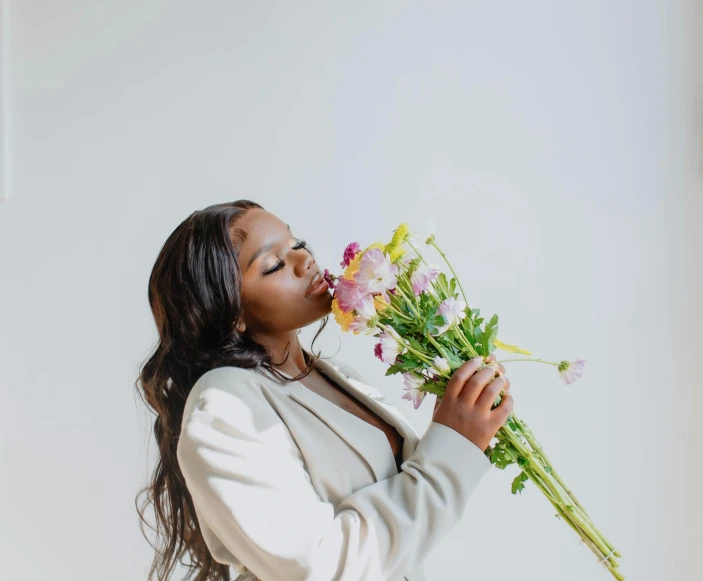 a woman blowing out her lips while holding flowers