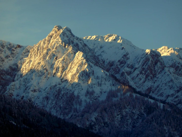 some snow covered mountains under a blue sky