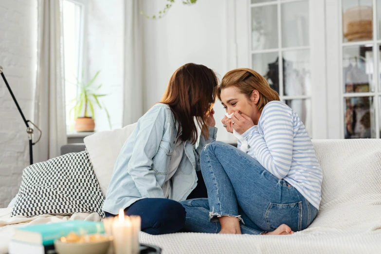 a couple of women sit on a couch