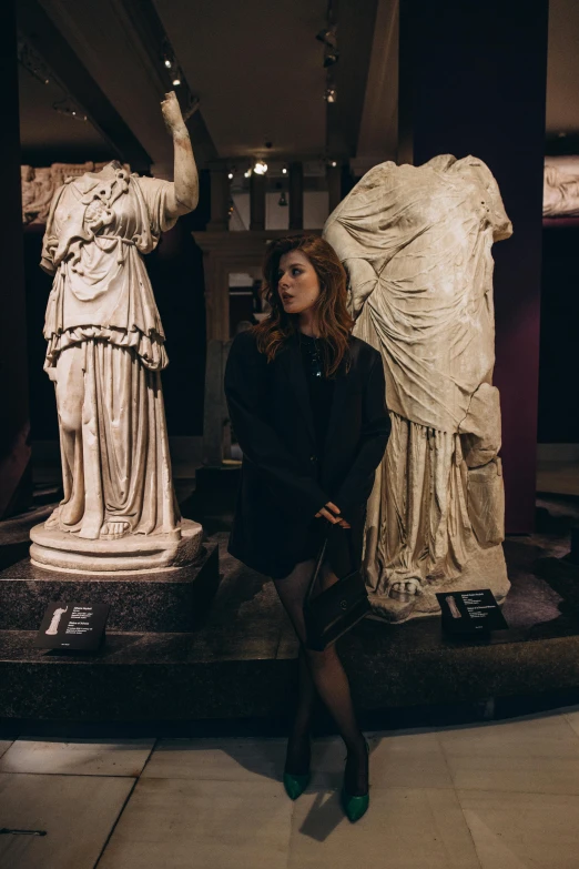 a woman posing for a po next to statues in a building