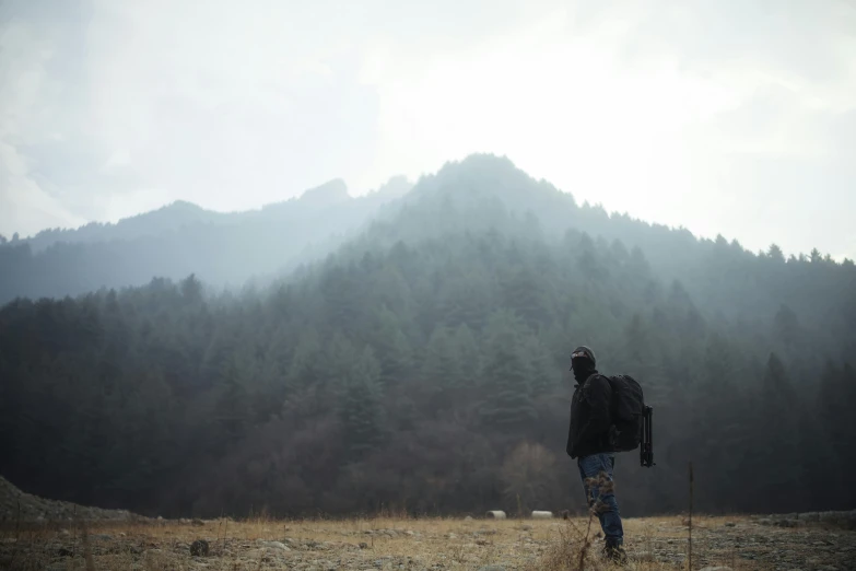 man on a foggy path with his backpack in hand